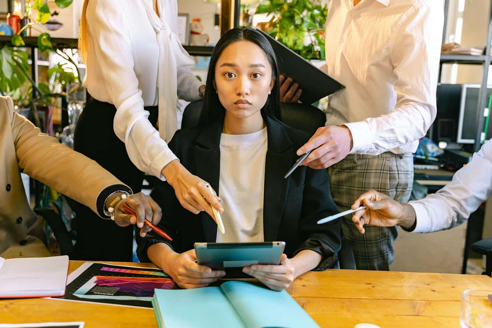 Frau mit Ipad beim Brainstorming mit ihren Kollegen